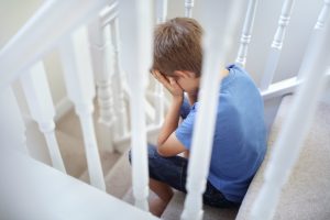 Upset boy on stairs
